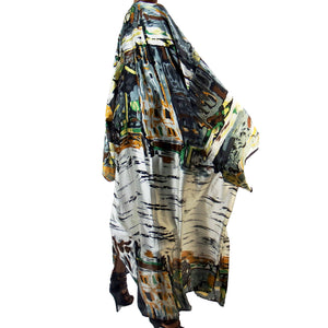 A woman models a luxury Japanese kimono robe in white with black trim, featuring subtle yellow and green tones with an abstract urban skyline design.