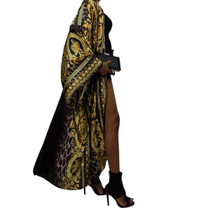 A woman models a luxurious black kimono robe adorned with a gold damask and leopard pattern, flowing gracefully for an elegant and bold statement.

A model showcases a black kimono jacket with gold damask and leopard accents, offering a stunning blend of luxury and modern chic in a flowing design.