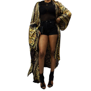 A woman models a luxurious black kimono robe adorned with a gold damask and leopard pattern, flowing gracefully for an elegant and bold statement.

A model showcases a black kimono jacket with gold damask and leopard accents, offering a stunning blend of luxury and modern chic in a flowing design.