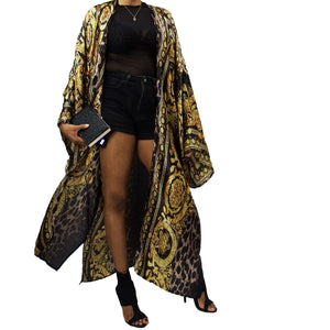 A woman models a luxurious black kimono robe adorned with a gold damask and leopard pattern, flowing gracefully for an elegant and bold statement.

A model showcases a black kimono jacket with gold damask and leopard accents, offering a stunning blend of luxury and modern chic in a flowing design.