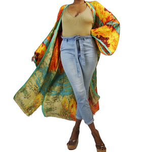 A woman models a flowing kimono robe in green and gold, featuring an abstract art print and mint-colored trim. The kimono jacket drapes elegantly.

A woman showcases a green and gold kimono robe with a striking abstract art print and mint-colored trim, highlighting the flowing fit of the kimono cardigan.