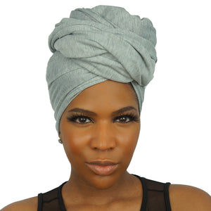 A model poses in a heather grey jersey knit stretch African headwrap, featuring a flexible and breathable fabric that provides a snug, stylish fit.