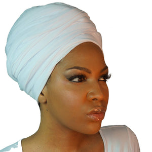 A woman models a white jersey knit stretch African headwrap, offering a comfortable and stylish look with a soft, stretchy fit perfect for any occasion.